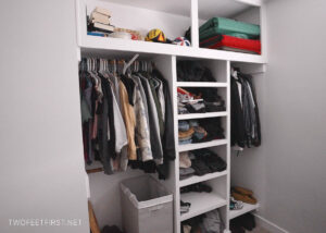 Finished closet organizer with clothes, shelves and hanging rods