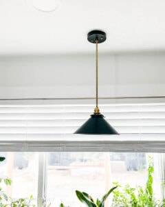HANGING BLACK AND GOLD PENDANT LIGHT with window in background