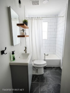 towel hook, full white tiled shower surround, floating shelves, dark bathroom tile