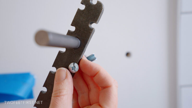 placing the screw into the hanging item where hole needs to be drilled