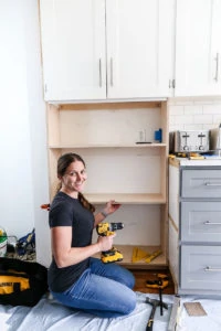 women building cabinet in kitchen