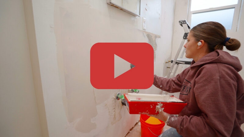 installing plaster mud on walls with video play icon 