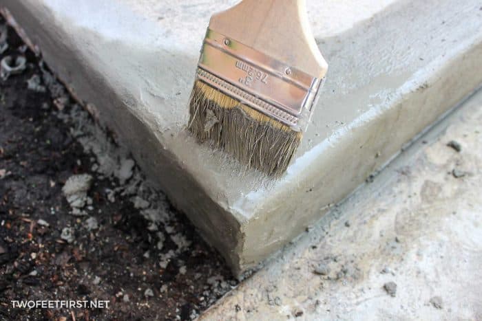 fixing concrete corner of step lightly brushing with paint brush